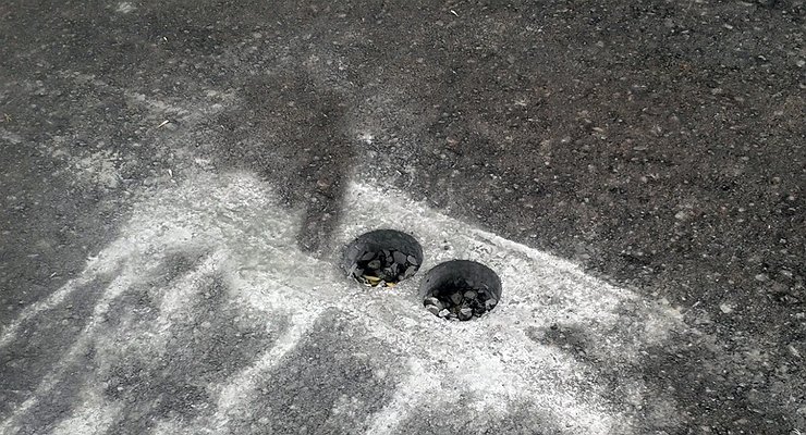 Why do we need strange, differently shaped holes on freshly laid asphalt?