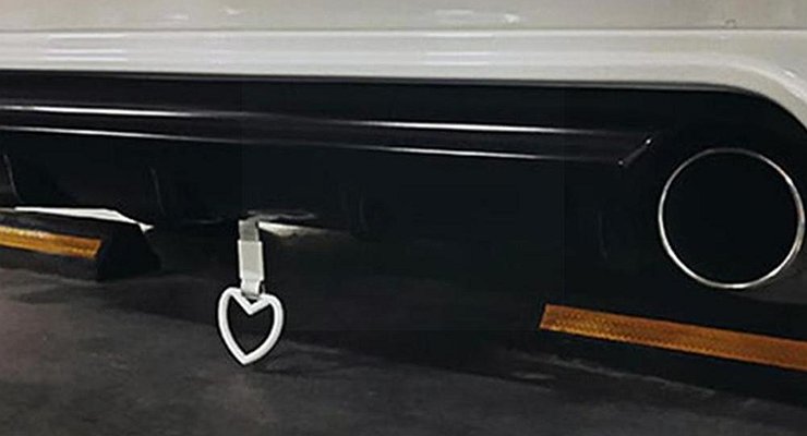 Why do some car owners hang a ring on the bumper of their car?