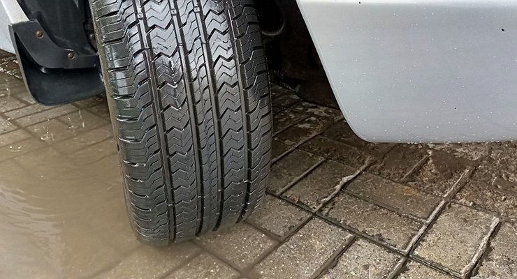 Why and how is it necessary to run in new tires on a car?