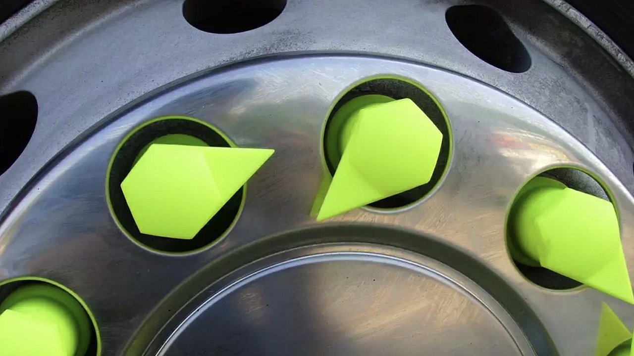 Why do truck drivers place special caps with arrows on wheel bolts?