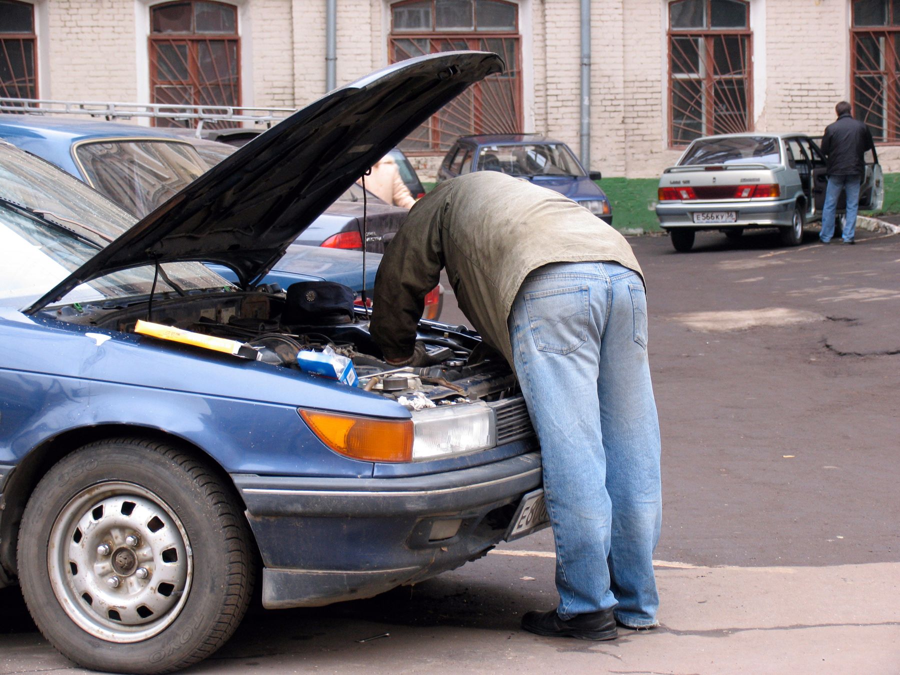 Скачай машину надо чинить. Человек чинит машину. Мужчина ремонтирует машину. Мужчина чинит машину. Мужик чинит тачку.