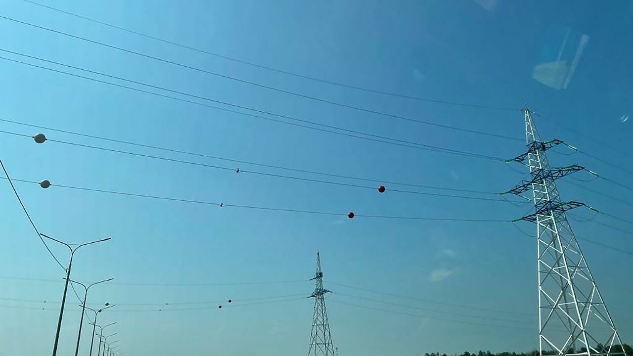 Зачем красные шары на высоковольтных проводах. Провода над дорогой. Шары на проводах ЛЭП над дорогой. Шары на линиях электропередач. Шары на линиях электропередач над дорогами.